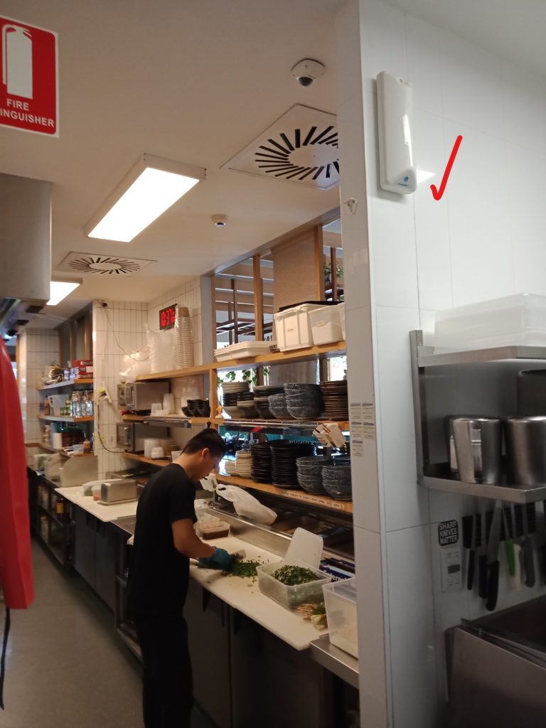 automatic fly spray on the wall in a commercial kitchen.